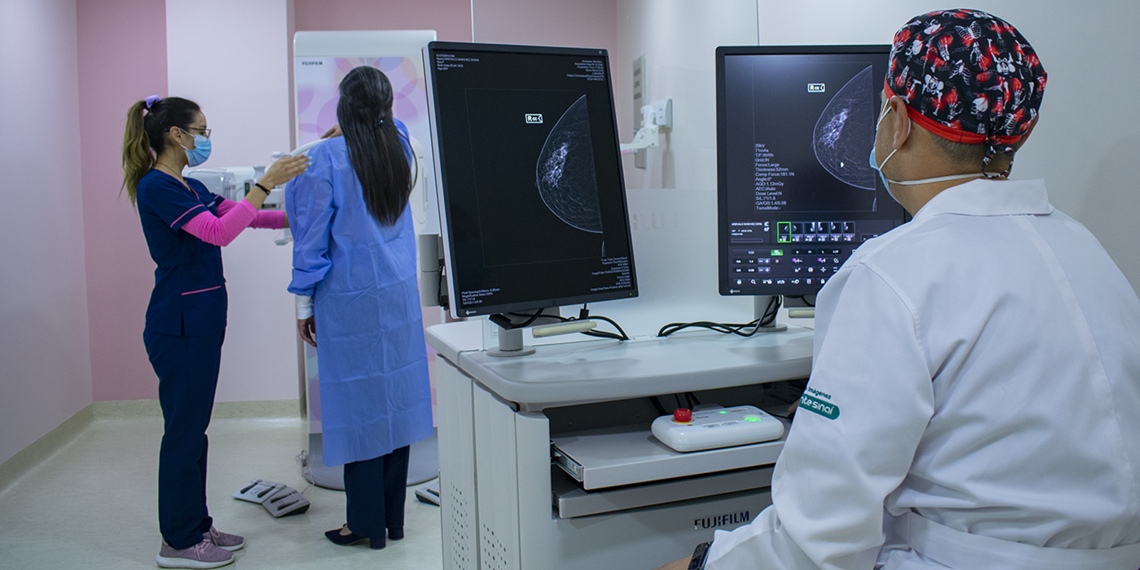 Doctor realizando mamografia a una paciente con la ayuda de asistente