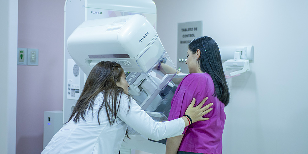 Doctora realizando examen de mamografía a paciente