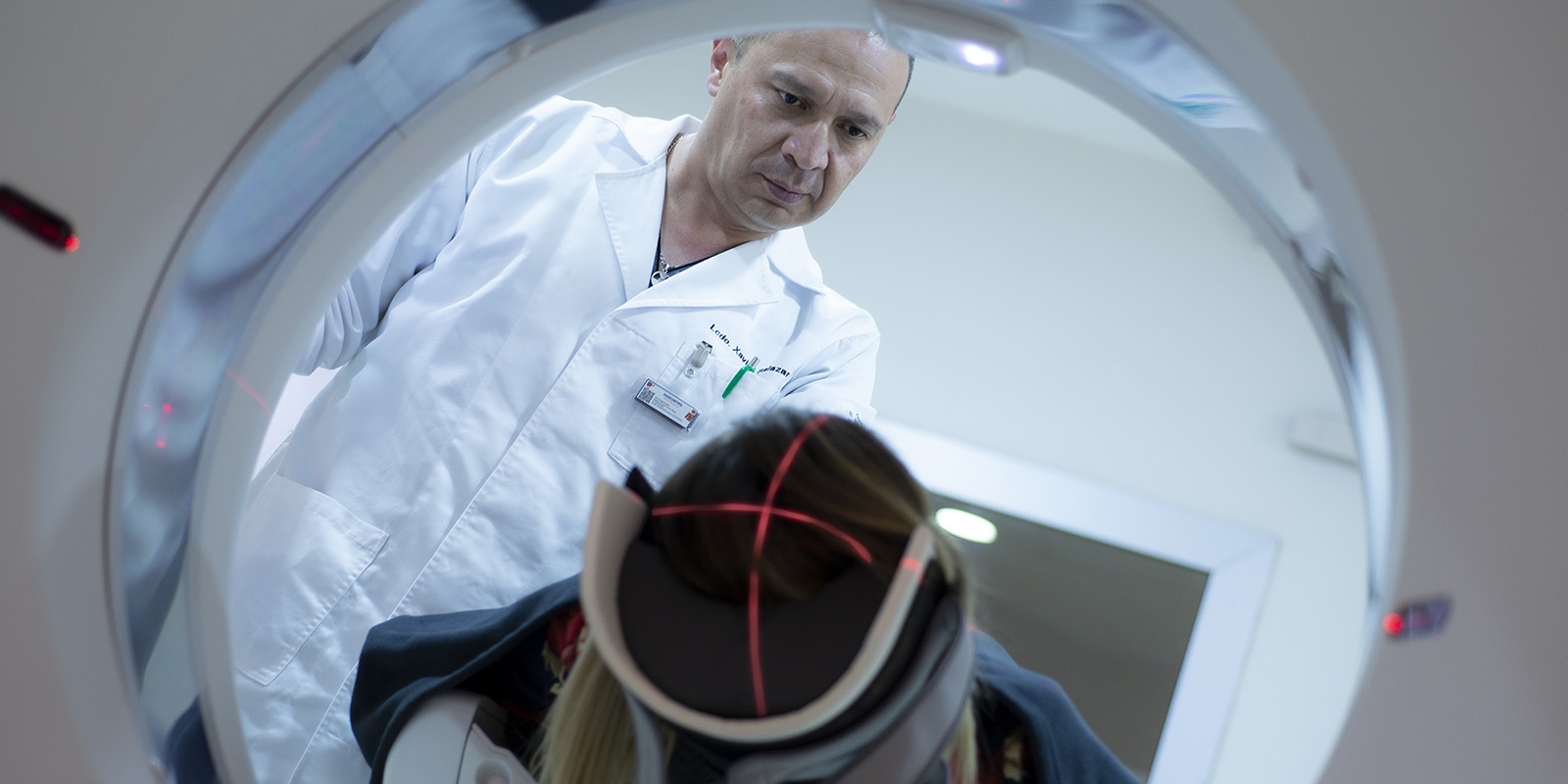 Doctor realizando examen de tomografia a mujer